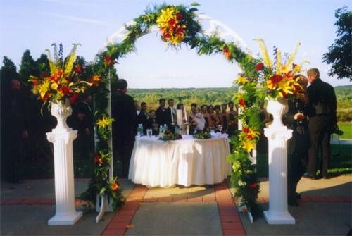 Formal 40 inch tall white pedestals.  White lattice, flat arch and white ceramic urns.